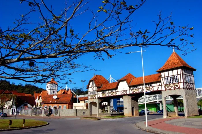 Foto do portal de Blumenau com arquitetura típica alemã, em contraste com céu azul.