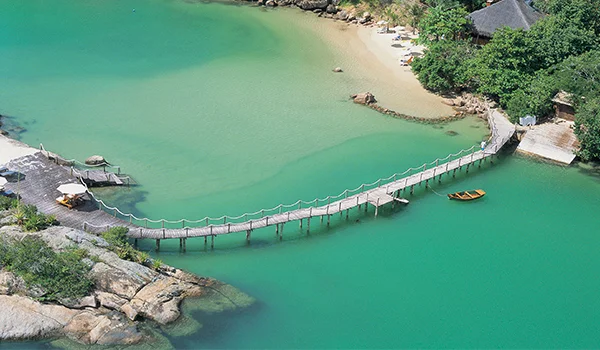Foto aérea do Hotel Awasi com um braço de mar verde e uma ponte entre os dois lados. Cenário perfeito para o o casamento em Ponta dos Ganchos.