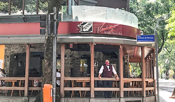 Lanchonete na rua com área ao ar livre, ambientes descontraídos e clientes curtindo a comida, ideal para quem busca uma experiência de comida de rua.