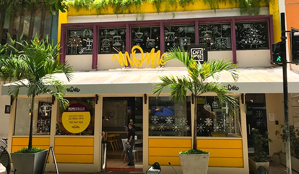 Foto de uma restaurante de Ipanema com fachada na cor amarela e plantas na calçada.