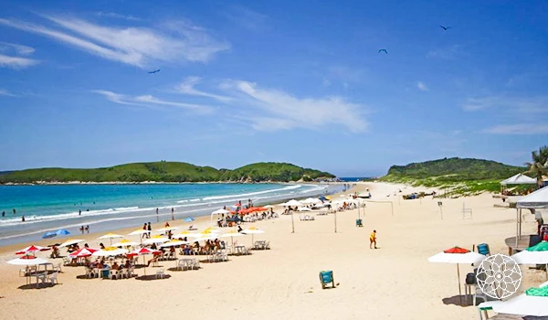 Foto de uma praia com mar azul e banhista na Lua de Mel em Cabo Frio