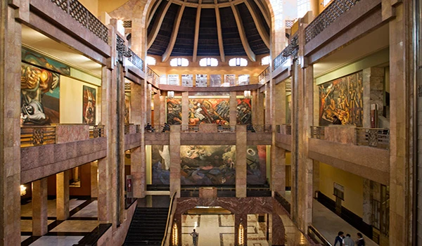 Imagem do interior de um museu com obras de arte em exibição, destacando uma arquitetura moderna com detalhes em mármore, iluminação natural e espaço amplo. Viagem ao México.