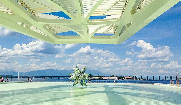 Imagem de uma estrutura moderna com vista para o mar, homenagem à palavra-chave e ao turismo na região, mostrando o céu azul e nuvens dispersas.
