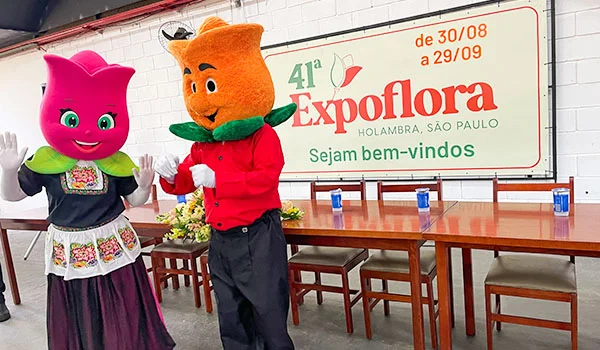 Foto de 2 bonecos vestidos de tulipas, rosa e laranja, durante a Expoflora e as flores de Holambra.