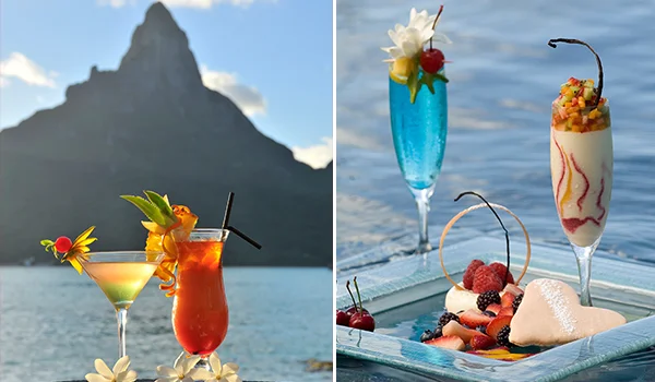 Fotografia de bebidas tropicais e sobremesas coloridas à beira-mar, tendo ao fundo uma imponente montanha rochosa. À esquerda, dois coquetéis decorados com flores e frutas; à direita, um drink azul, uma sobremesa em taça e um prato com frutas vermelhas e sorvete.