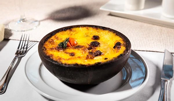 Saboroso prato chileno em uma tigela preta, ideal para uma refeição reconfortante. Perfeito para quem busca receitas tradicionais.