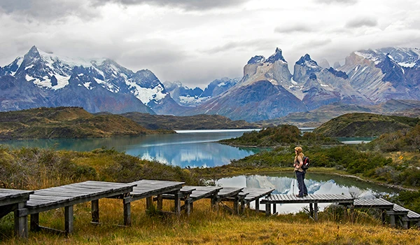 Montanhas cobertas de neve sob um céu azul, destacando as formações rochosas e o cenário de inverno na natureza selvagem.