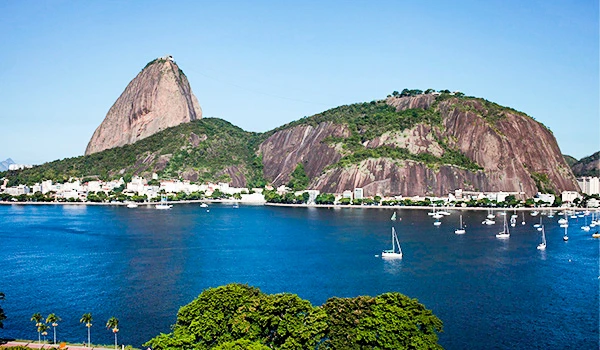 Vista panorâmica do Pão de Açúcar no Rio de Janeiro, com suas rochas icônicas, mar azul e barcos na baía, destaque turístico e paisagístico do Brasil.