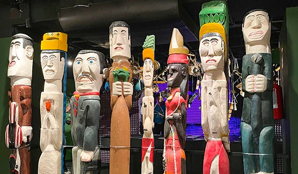 Imagem de tochos decorativos com faces pintadas e diferentes expressões, usados na cultura e festas tradicionais.