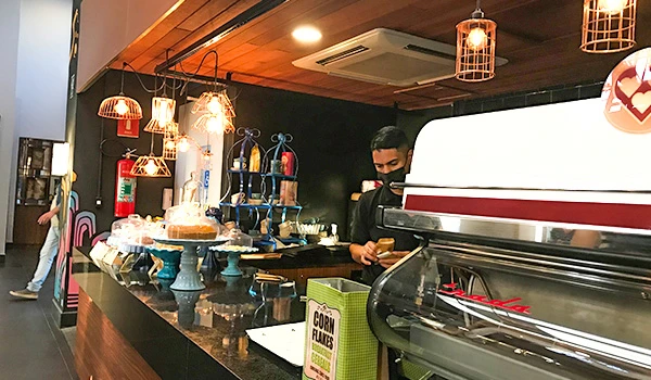 Café do 26 decorada com luminárias modernas e cores quentes, ideal para quem busca um café de qualidade.