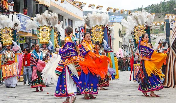 Coreografia tradicional de dança folclórica do Equador durante festival cultural com bailarinas em trajes coloridos e decoração típica ao fundo. Cultura e as danças da América do Sul.
