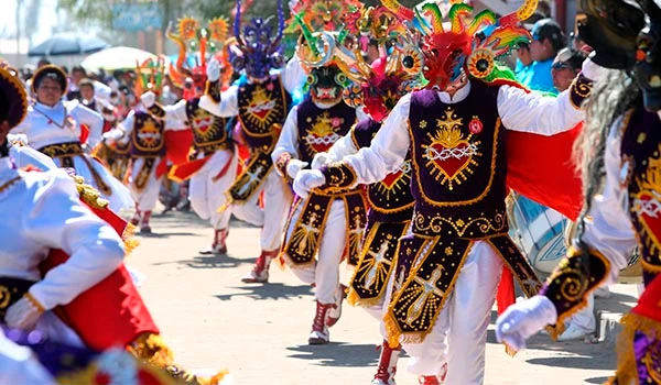 Grupo de pessoas dançando durante uma festividade tradicional com máscaras coloridas e roupas decoradas, celebrando uma cultura do Chile. Cultura e as danças da América do Sul.