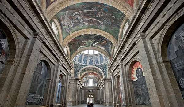 Imagem de uma belo monumento com arcos e murals históricos no teto, decorada com detalhes arquitetônicos clássicos, ideal para visitar e apreciar a arte. O que fazer em Guadalajara.