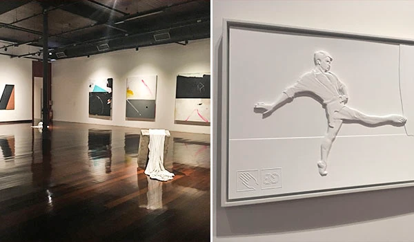 Exposição de obras de arte moderna e contemporânea em um museu, com pinturas abstratas no paredes e uma escultura branca de um item decorativo na sala.