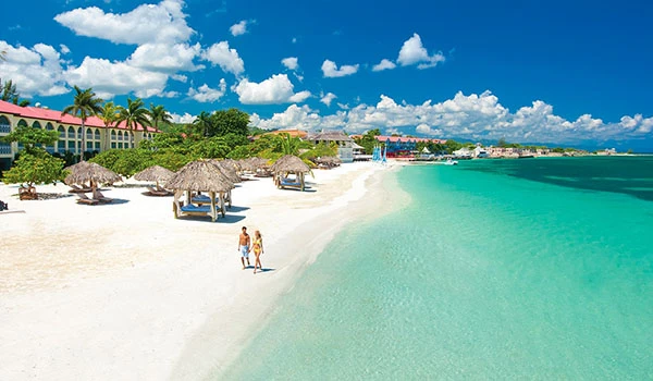 Jamaica praias de areia branca com cabanas de palha, águas cristalinas e céu ensolarado, ideal para férias relaxantes em um destino paradisíaco.