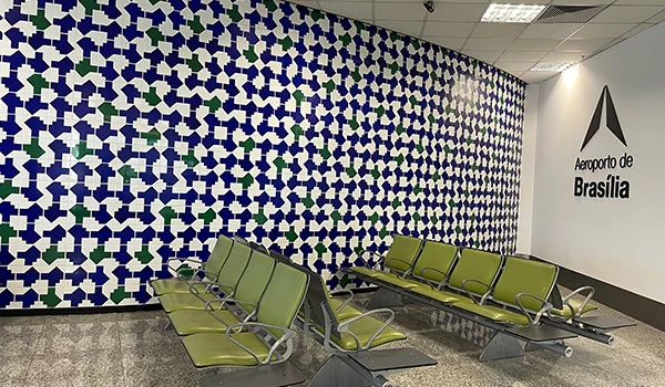 Aeroporto de Brasília com sua famosa parede decorativa de azulejos em padrão geométrico. Espaço moderno e confortável para os passageiros.