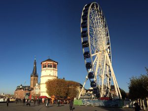 Imagem de uma roda gigante na cidade de Düsseldorf no final da tarde.