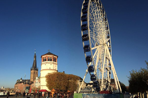 Imagem de uma roda gigante na cidade de Düsseldorf no final da tarde.