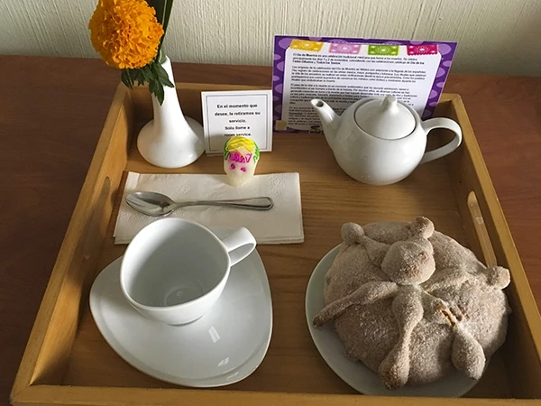 Café da manhã com bolo decorativo, chá, café e flores em uma bandeja de madeira