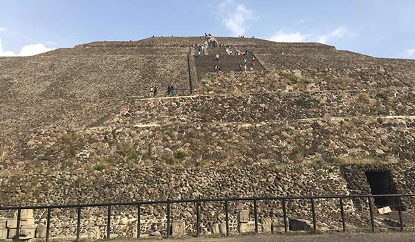 Pirâmides do Sol e da Lua com foto da subida com várias pessoas nas escadas em contraste com céu azul.