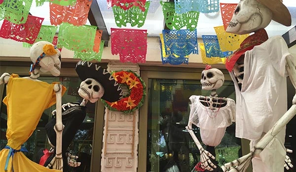 Decoração de Dia dos Mortos com esqueletos decorativos, papel colorido e elemento de caveira, ideal para festas tradicionais do México.