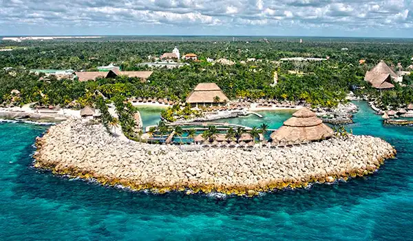 Imagem aérea de um resort de praia na Riviera Maya, com palmeiras, cabanas à beira-mar e belas águas azuis do Caribe, perfeito para férias e relaxamento. Lua de Mel em Cancun.