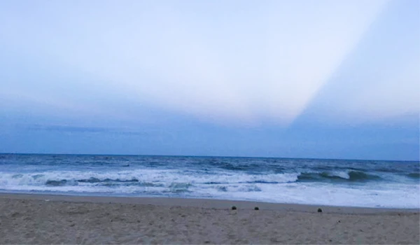 Praia com mar calmo e céu claro ao entardecer, ideal para passeios e relaxamento à beira-mar. Fortaleza o que fazer.