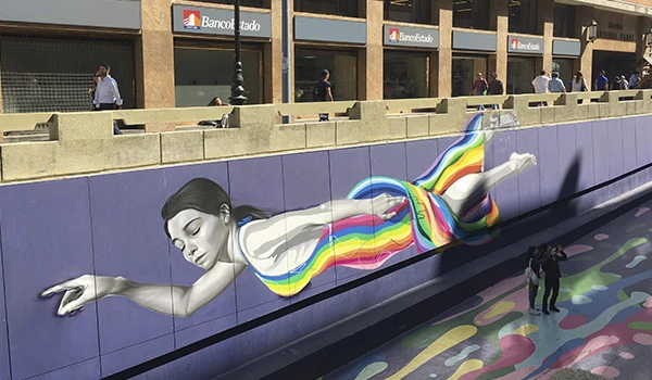 Arte de rua representando uma mulher deitada, com cores vibrantes, que transmite criatividade e liberdade na cidade.