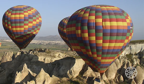 Balões de ar quente coloridos sobrevoam as formações rochosas da Capadócia, na Turquia, durante um passeio ao amanhecer.