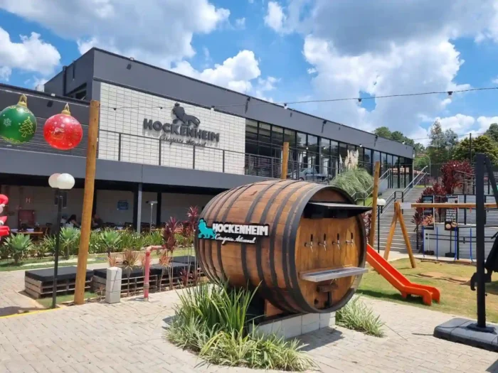 Foto de cervejaria na Estrada do Vinho em São Roque, construção moderna e barril de cerveja no jardim.