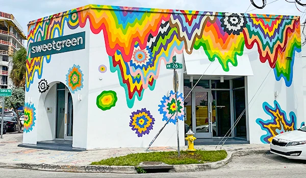 Loja Sweetgreen com fachada decorada com arte colorida e vibrante, destacando inovação e sustentabilidade no bairro de Miami.