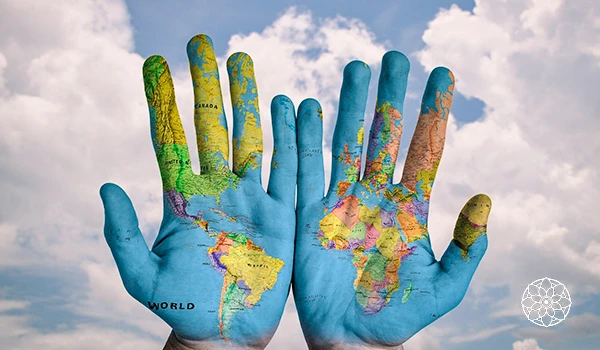 Imagem de mãos pintadas com mapas do mundo, simbolizando a globalização e a conexão entre nações. A arte destaca continentes e oceanos.