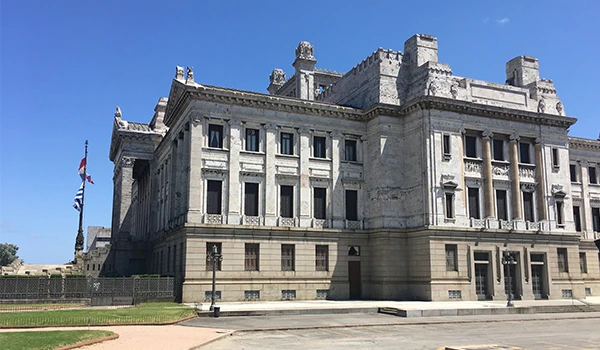 Majestoso castelo de pedra com arquitetura imponente, localizado ao ar livre sob céu azul claro, ideal para turismo histórico.
