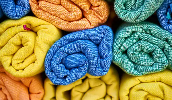 Imagens de lenços coloridos e enroladas que adicionam um toque vibrante a qualquer ambiente. Dicas para presente quem gosta de viajar.
