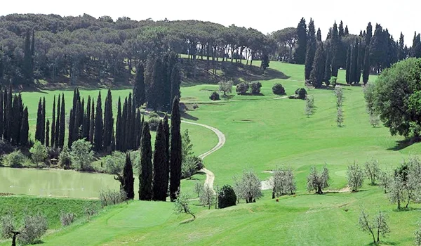 Colinas verdes com fileiras de ciprestes, oliveiras, árvores e um pequeno lago em uma paisagem típica e cenário mágico da Lua de Mel na Toscana.