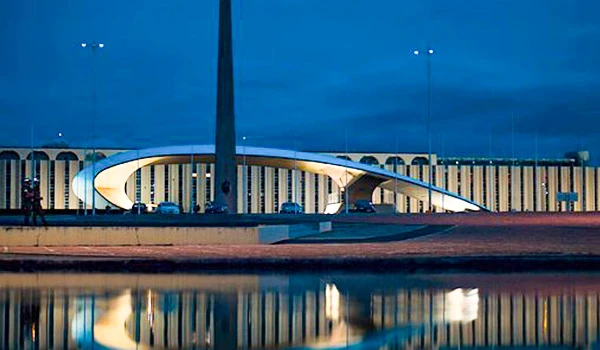 Imagem da praça dos Cristais ao entardecer, com sua arquitetura moderna e refletida na água. Lua de Mel em Brasília.