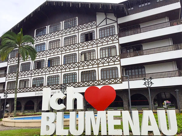 Edifício no Blumenau com fachada moderna e decoração charmosa, inclusive uma placa com o texto "Ich Love Blumenau". Ideal para turismo na cidade.
