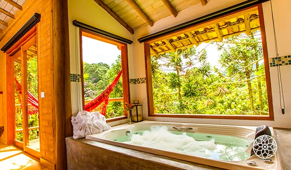 Banheira de hidromassagem em ambiente aconchegante com vistas para a natureza, ideal para relaxamento e tranquilidade.