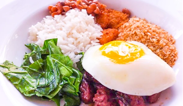 Prato típico da culinária mineira com arroz, feijão, ovo frito, carne, farofa e verduras. Uma refeição colorida e nutritiva.
