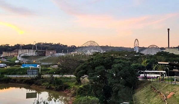 Vista de longe das atrações do Parque Hopi Hari junto à rodovia, em meio ao verde a região.