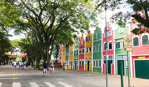 Cores vibrantes e arquitetura encantadora caracterizam as casas ao longo da rua, cercadas por árvores, criando um ambiente perfeito para passeios. Holambra é um dos lugares baratos para Lua de Mel em SP.