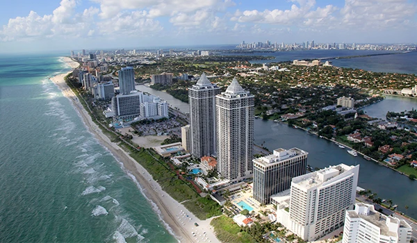 Vista panorâmica da costa de Miami, mostrando arranha-céus, praia e águas cristalinas. Uma imagem que capta a beleza urbana e natural da cidade, destino ideal para a Lua de Mel em Miami.