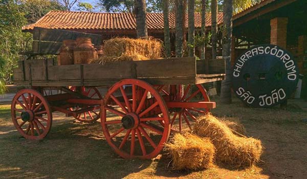 Hotel Fazenda São João na cidade de São Pedro, interior de São Paulo, com passeios a cavalo, foto de um carro de boi com nego e uma placa com os dizeres: Churracódromo São João.