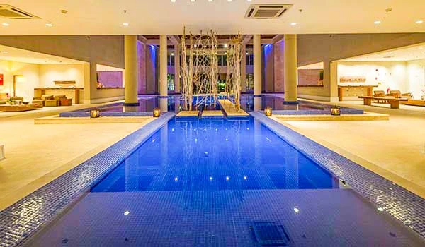 Imagem de um luxuoso espaço de piscina com iluminação suave e ambiente moderno, ideal para relaxamento e lazer.