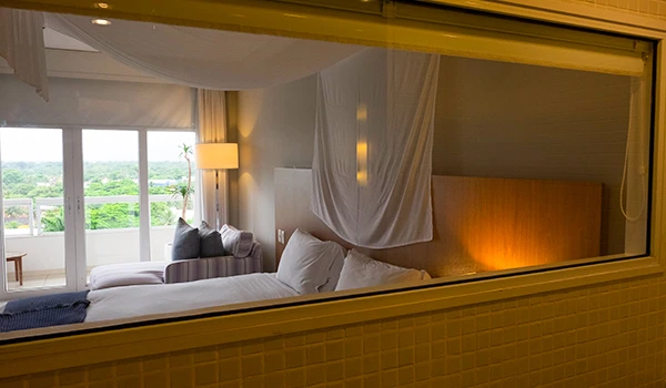 Vista interna de um quarto de hotel elegante com iluminação suave e decoração moderna, ideal para relaxar em um ambiente aconchegante e tranquilo.