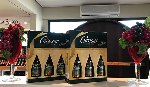 Caixas de bebidas Cereser expostas em ambiente elegante com decoração de uvas e flores, ideal para festas e celebrações. Um dos passeios para conhecer café colonial e vinícolas de Jundiaí.