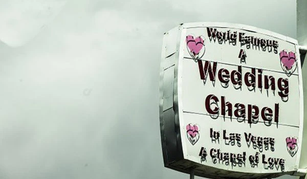 Sinalização para uma capela de casamento em Las Vegas, destacando sua fama mundial e decoração com corações rosas. Casamento e renovação de votos no exterior.