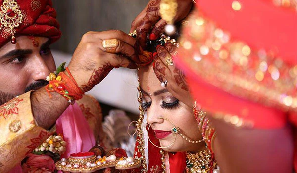 Casal de noivos indianos em cerimônia de casamento tradicional, com roupas e acessórios típicos e detalhes ricos em cultura e celebração.