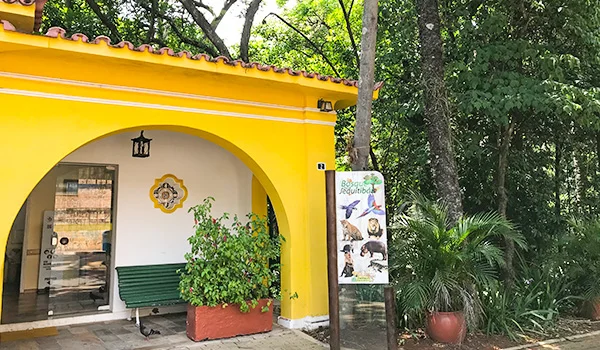 Foto da entrada com uma casa de cor amarela no Bosque dos Jequitibás em Campinas.