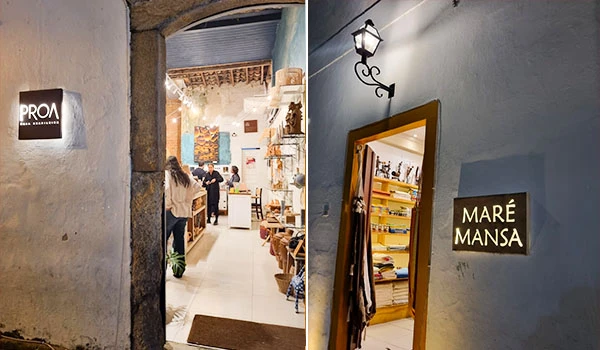 Imagem interna de uma loja de decoração com iluminação aconchegante, prateleiras com livros e objetos decorativos, além de clientes explorando o espaço.